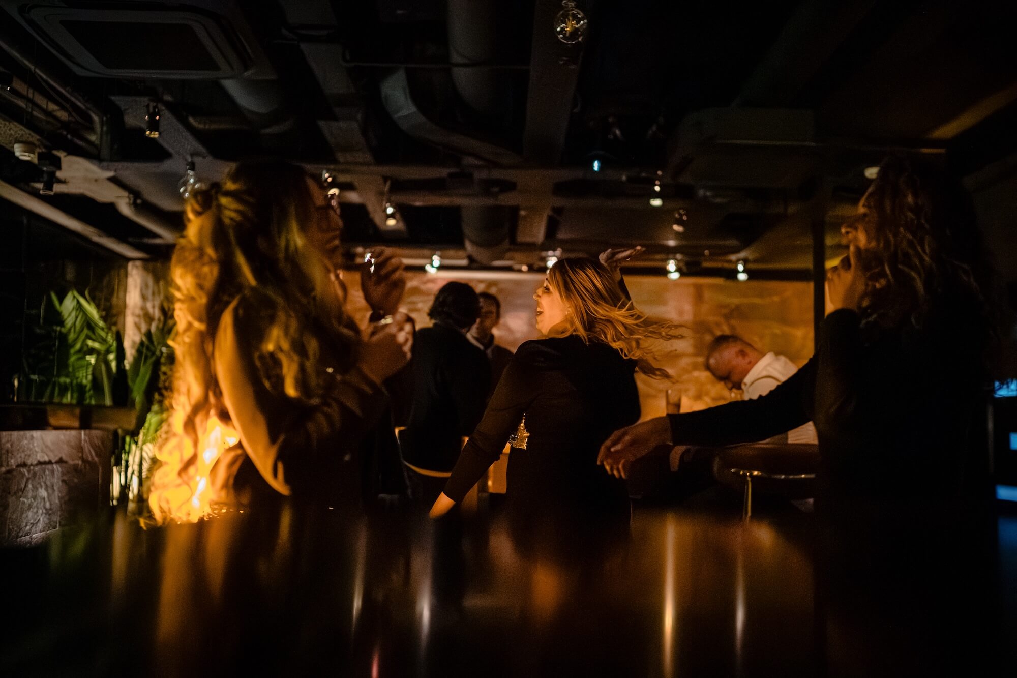Guests celebrating and dancing at the bar during an engagement party at PÚRL Barbican, London