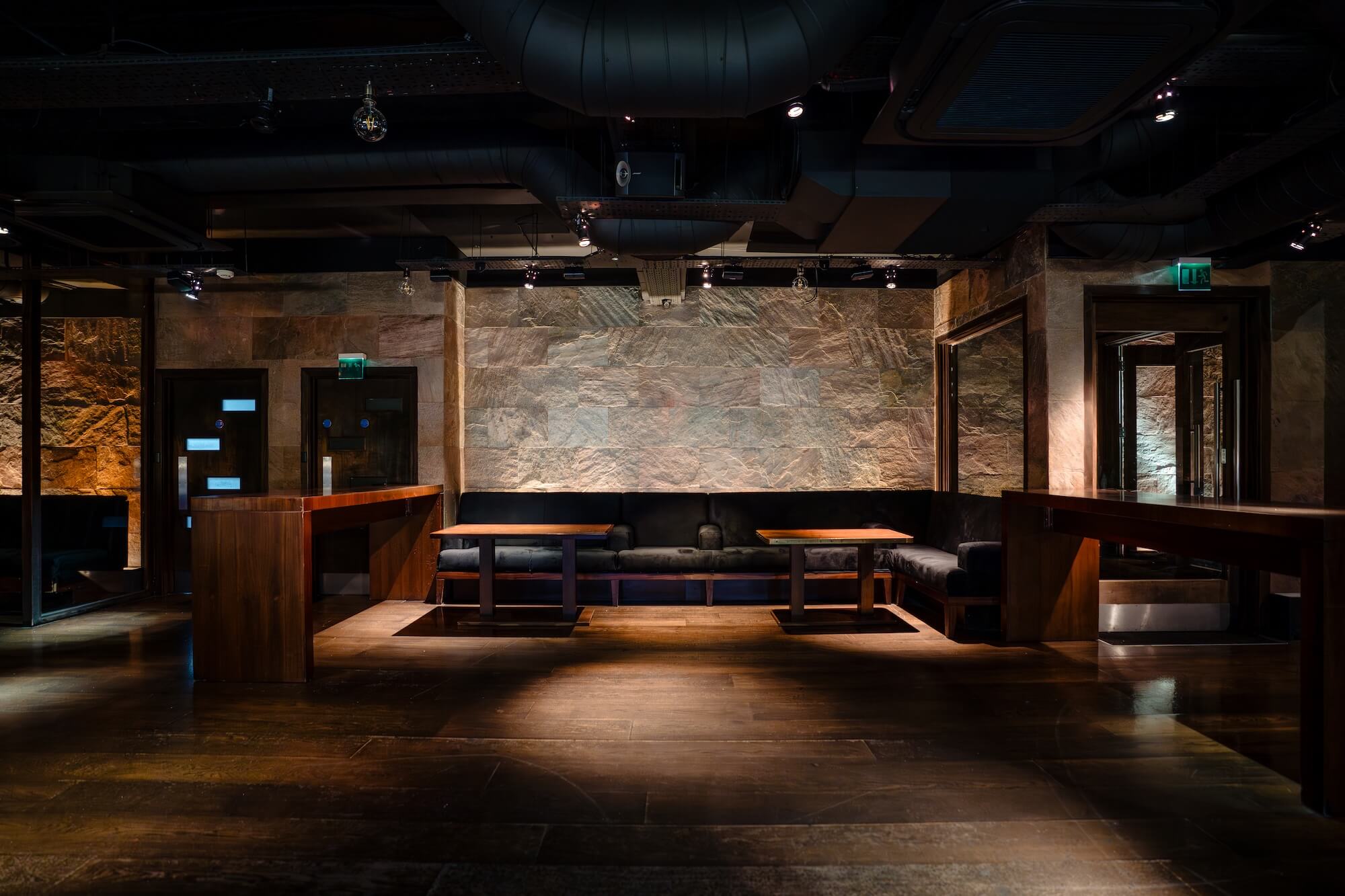 Exposed stone walls and warm lighting in the underground private event space at Purl Barbican, London