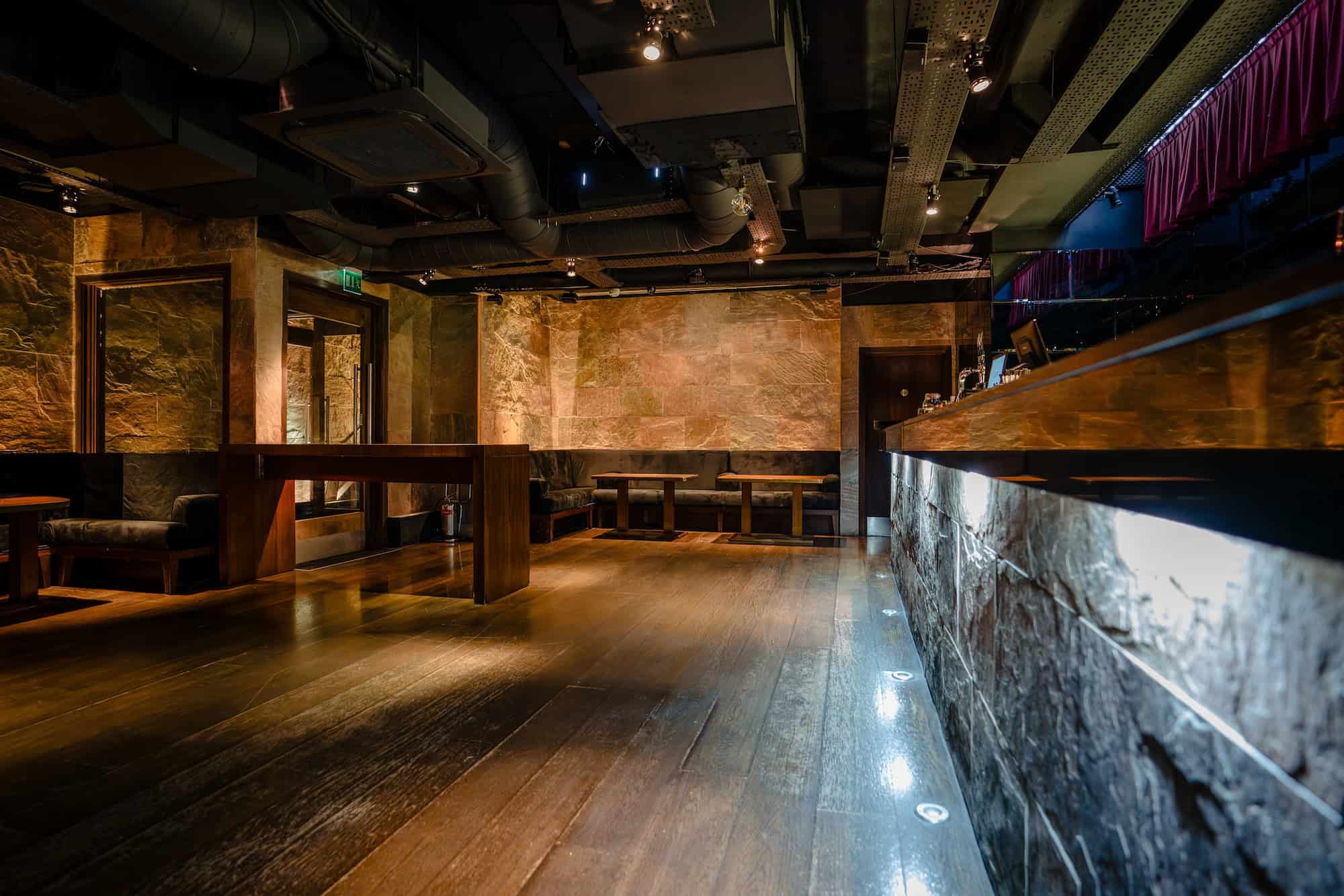 Sophisticated interior details of Purl Barbican private hire room with brass accents, exposed brickwork, and ambient light